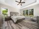 Bright main bedroom with tray ceilings, large windows, and hardwood flooring at 8828 Deerland Grove Dr, Raleigh, NC 27615