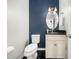 Stylish powder room featuring a dark blue accent wall, modern fixtures, and elegant finishes at 8828 Deerland Grove Dr, Raleigh, NC 27615