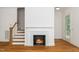 Cozy fireplace with white mantel, hardwood floors, and staircase nearby in a well-lit room at 905 Deboy St, Raleigh, NC 27606