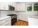 White kitchen with stainless steel appliances, including oven, and ample cabinet and countertop space at 905 Deboy St, Raleigh, NC 27606