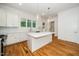 Bright kitchen features white cabinets, island with countertop, stainless steel appliances, hardwood floors, and natural light at 905 Deboy St, Raleigh, NC 27606