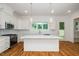 Open kitchen with white cabinets, stainless appliances, island, and large window bringing in natural light at 905 Deboy St, Raleigh, NC 27606