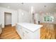 Bright open-concept kitchen with white island, stainless steel appliances, and hardwood flooring throughout at 905 Deboy St, Raleigh, NC 27606