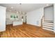 Bright interior with hardwood floors, a view of the kitchen, and a staircase leading to the second floor at 905 Deboy St, Raleigh, NC 27606
