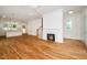 Hardwood floors complement a cozy fireplace and open floor plan leading to a modern kitchen at 905 Deboy St, Raleigh, NC 27606