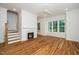 Well-lit living room features a cozy fireplace, hardwood floors, and staircase access to the second floor at 905 Deboy St, Raleigh, NC 27606
