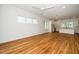 Open-concept living room with hardwood floors, bright windows, and a view into the modern white kitchen at 905 Deboy St, Raleigh, NC 27606