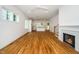 Spacious living room featuring hardwood floors, a cozy fireplace, and an open view of the kitchen area at 905 Deboy St, Raleigh, NC 27606