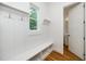 Mudroom features built-in bench with storage, hooks, a window, and a doorway leading to a powder room at 905 Deboy St, Raleigh, NC 27606