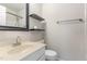 A clean, well-lit bathroom with a white vanity, toilet, and decorative shelves at 9709 Batesville Dr, Raleigh, NC 27617