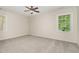 Bright bedroom with neutral walls, carpet, ceiling fan, and large windows at 9709 Batesville Dr, Raleigh, NC 27617