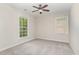 A well-lit bedroom with a ceiling fan, plush carpeting, and large windows at 9709 Batesville Dr, Raleigh, NC 27617