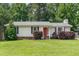 Charming single-story home with a well-maintained lawn, red front door and manicured shrubbery at 9709 Batesville Dr, Raleigh, NC 27617