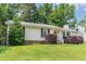 Charming single-story home with a well-maintained lawn, red front door and manicured shrubbery at 9709 Batesville Dr, Raleigh, NC 27617