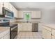 A bright kitchen featuring a stainless steel dishwasher and a view from the window at 9709 Batesville Dr, Raleigh, NC 27617