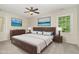 Cozy main bedroom featuring a large bed, ceiling fan, and bright windows for natural light at 9709 Batesville Dr, Raleigh, NC 27617