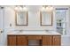 Bathroom featuring double sinks with wood cabinets and a window for natural light at 9728 Batesville Dr, Raleigh, NC 27617
