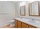 Bathroom with double sinks, light wood cabinets, and large mirrors with vanity lights at 9728 Batesville Dr, Raleigh, NC 27617