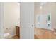 Bathroom with a toilet, sink, and wood floors near the entryway and stairs at 9728 Batesville Dr, Raleigh, NC 27617