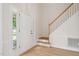 Bright foyer featuring hardwood floors, a white front door with sidelight, and a staircase with wood handrail at 9728 Batesville Dr, Raleigh, NC 27617