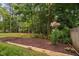 Garden bed features wooden border, mulch, pink lilies, and manicured shrubbery at 9728 Batesville Dr, Raleigh, NC 27617