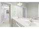 Bright bathroom featuring double sink vanity, tile floors, and glass-enclosed shower at 1003 Blackberry Ln, Durham, NC 27712