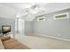 This bonus bedroom boasts large windows, a ceiling fan, and a TV with a neutral color scheme at 1003 Blackberry Ln, Durham, NC 27712