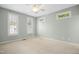 Empty bedroom featuring carpeted floors, ceiling fan, and many windows at 1003 Blackberry Ln, Durham, NC 27712