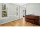 Bright, empty room with hardwood floors, large windows, and piano at 1003 Blackberry Ln, Durham, NC 27712