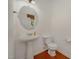 Traditional powder room features a pedestal sink, wood floors, and oval mirror at 1016 Kingston Grove Dr, Cary, NC 27519