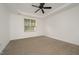 A bedroom with a ceiling fan and neutral carpet receives natural light through a window at 1016 Kingston Grove Dr, Cary, NC 27519