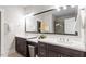 Bathroom with double vanity, large mirror, and dark cabinets at 10310 Sablewood Dr # 115, Raleigh, NC 27617