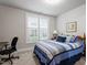 Comfortable bedroom with a large window, desk, and blue and white bedding at 10310 Sablewood Dr # 115, Raleigh, NC 27617