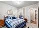 Bedroom with blue bedding, mirrored closet doors, and neutral walls at 10310 Sablewood Dr # 115, Raleigh, NC 27617