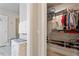 Walk-in closet with hanging clothes, shelving, and access to shower at 10310 Sablewood Dr # 115, Raleigh, NC 27617