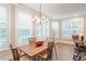 Bright dining area with large windows, a stylish chandelier, and a hardwood table with seating at 10310 Sablewood Dr # 115, Raleigh, NC 27617