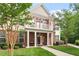 Inviting brick townhome boasts a second-story balcony, covered porch, and lush green landscaping at 10310 Sablewood Dr # 115, Raleigh, NC 27617