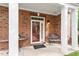 Covered porch features brick columns, bench seating, and a charming front door with glass panels at 10310 Sablewood Dr # 115, Raleigh, NC 27617