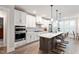 Bright kitchen boasts stainless appliances, white cabinets, large island, and hardwood floors at 10310 Sablewood Dr # 115, Raleigh, NC 27617