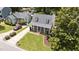 Aerial view of a home featuring a manicured lawn, driveway, covered porch and dormer windows at 1033 Mills St, Raleigh, NC 27608