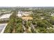 Wide aerial perspective featuring houses, commercial properties, trees, and the city skyline in the distance at 1033 Mills St, Raleigh, NC 27608