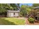 Backyard featuring a storage shed, stone fire pit, green grass and nice landscaping at 1033 Mills St, Raleigh, NC 27608