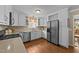 Updated kitchen with white cabinetry, stainless steel appliances, and hardwood flooring offering modern functionality at 1033 Mills St, Raleigh, NC 27608