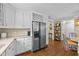 Well-lit kitchen with stainless steel refrigerator, white cabinets, and hardwood floors providing ample storage and workspace at 1033 Mills St, Raleigh, NC 27608