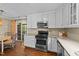 Bright kitchen featuring stainless steel appliances, white cabinets, and backyard access enhancing convenience and style at 1033 Mills St, Raleigh, NC 27608
