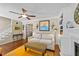 Comfortable living room featuring hardwood floors, a ceiling fan, and a decorative fireplace with built-in shelving at 1033 Mills St, Raleigh, NC 27608