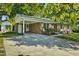 Charming brick home featuring a covered carport and well-maintained front yard with mature trees at 104 S Tunstall St, Apex, NC 27502