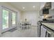 Kitchen with modern appliances, bright tile floors, and a breakfast table near the patio door at 104 S Tunstall St, Apex, NC 27502