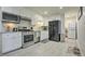 Modern kitchen featuring stainless steel appliances, white cabinets, and neutral tile flooring at 104 S Tunstall St, Apex, NC 27502