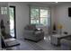 Bright living room boasts a large window, neutral gray decor, and modern finishes at 104 S Tunstall St, Apex, NC 27502